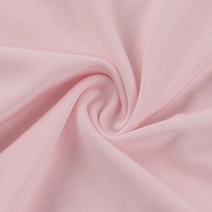 Detailed macro view of soft pink ribbed fabric texture with elegant twisted drape effect