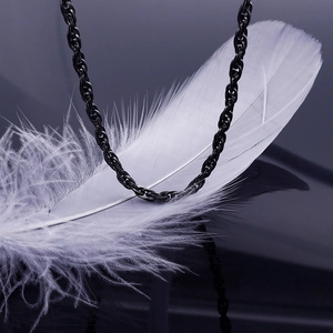 Close-up of a black twisted rope chain necklace resting on a soft white feather