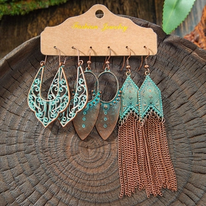 Vintage 3-piece bohemian earring set with turquoise blue finish on a rustic wood background