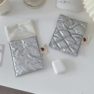 Macro detail of silver quilted heart pouch with snap button and soft fleece lining