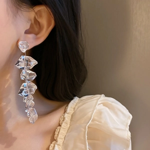 Detail view of long geometric earrings with irregular clear acrylic ice-like crystals