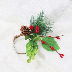 Christmas napkin ring with red berries, pine cones and green leaves on white plush background