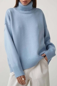 Détail du pull à col roulé bleu clair avec poignets côtelés et texture en maille douce