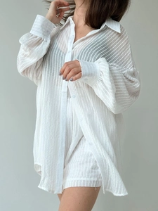 Detail of white textured striped shirt fabric with long sleeves and buttons