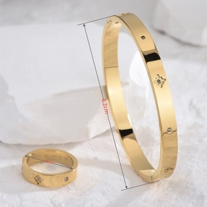 Detail view of star pattern gold bracelet and ring set with 6.2cm and 2cm dimensions