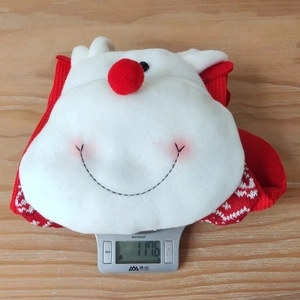 Detail view of a plush Christmas stocking weighing 117.6g on a digital kitchen scale