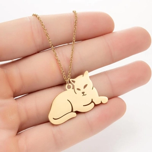 Gros plan d'un pendentif chat allongé en acier inoxydable doré à l'or 18 carats sur chaîne