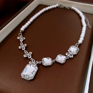 Vue macro d'un collier argenté avec cristal rectangulaire et perles dans un coffret