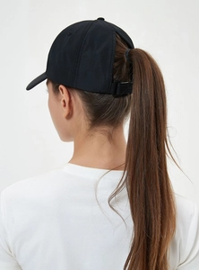 Detail of adjustable black ponytail baseball cap showing the functional rear opening