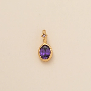 Close-up of golden birthstone pendant with purple oval zircon and diamond decoration