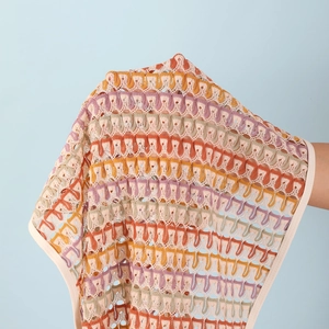Gros plan sur un tissu au crochet évidé avec motifs de vagues colorées et doux