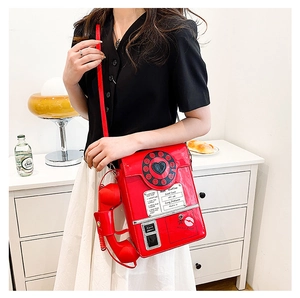 Detail of red telephone shaped bag featuring retro dial print and phone handset accessory