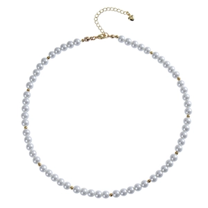 Detail of bohemian pearl necklace with gold beads and heart-shaped extension chain