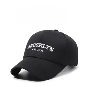 Close-up of white Brooklyn embroidery on a classic black cotton baseball cap