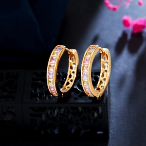 Golden hoop earrings with colorful cubic zirconia stones on professional display stand