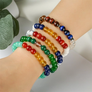 Close-up of model wearing multiple 8mm tiger eye and agate beaded elastic bracelets