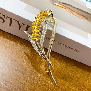 Elegant crystal wheat ear hair clip with golden rhinestones on white wooden background