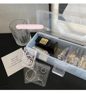 Macro shot of portable desktop jewelry organizer with adjustable dividers and clear lid