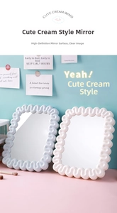 Detail of cream style desktop makeup mirrors with wavy frames in blue and white colors