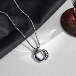 Close-up of interlocking silver and blue triple rings pendant on a titanium steel chain
