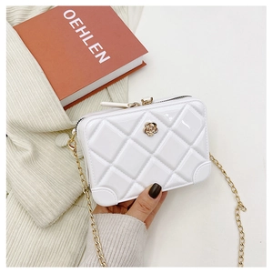 Close-up of a white quilted PVC jelly bag with a gold flower buckle and chain strap