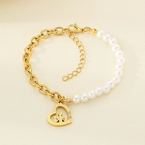 Close-up of golden heart pendant with mother and child silhouette on a pearl chain