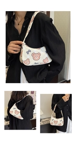 Close-up of cream shoulder bag featuring cute cartoon bears and bows printed on surface