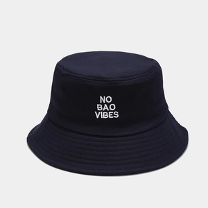 Close-up of white 'NO BAO VIBES' embroidery on a navy blue cotton fisherman bucket hat