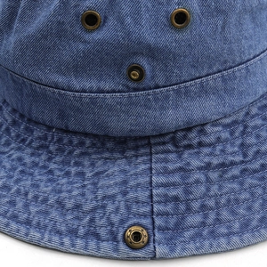 Détail du chapeau de soleil en jean bleu avec œillets métalliques et coutures renforcées