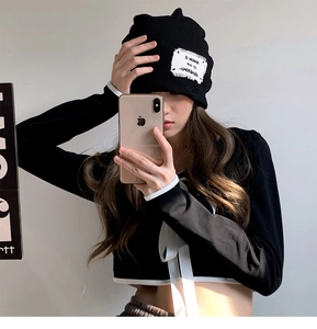 Close-up of black knitted cat ear beanie with embroidered patch for a trendy look
