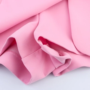 Close-up of pink knit fabric texture and slit hem detail on women's spring skort
