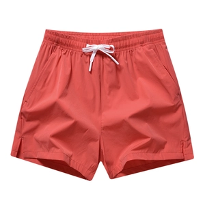 Quick-dry men's athletic shorts in brick red with elastic waist and side split hem