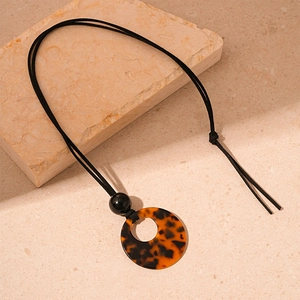 Detail of vintage acrylic leopard print ring pendant on an adjustable black cord necklace