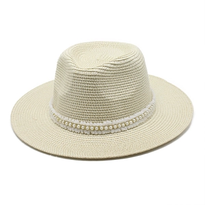 Détail d'un chapeau de paille Panama avec bordure élégante en dentelle de perles blanches