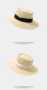 Détail de deux chapeaux de paille avec rubans noir et beige pour protection solaire