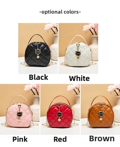Detail of round quilted mini bag featuring cat-shaped charm and metal chain strap