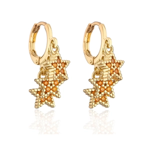 Macro shot of 18K gold plated star earrings with inlaid orange zircon stones