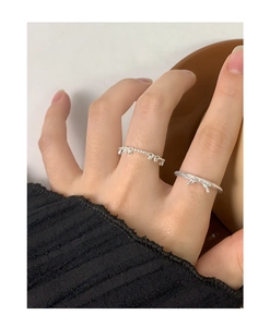 Close-up of minimalist S925 silver rings with bow and bead designs on a model hand