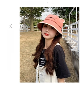 Detailed view of pink cat ear sun hat with black whiskers embroidery and cream lining