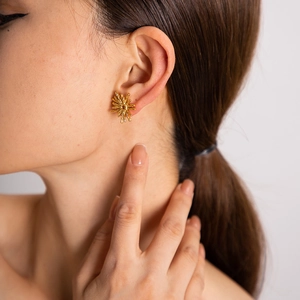 Boucles d'oreilles vintage françaises en acier inoxydable doré portées par un mannequin