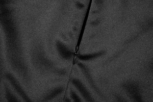 Close-up of the high-quality invisible zipper on a black satin slit summer dress