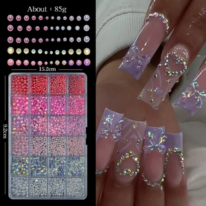 Detailed view of 24-compartment nail art kit with pink pearls and iridescent rhinestones