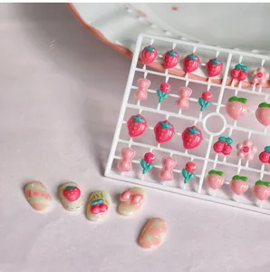 Vue détaillée de charms d'ongles en résine avec fraises, cerises et fleurs en 3D