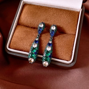 Detail of vintage teardrop earrings with multicolor zircon in a brown velvet box
