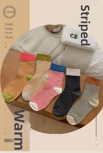 Gros plan de cinq paires de chaussettes en coton à rayures aux couleurs chaudes d'automne
