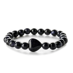 Dettaglio macro del bracciale con perline di pietra blu e pietra centrale a cuore