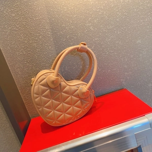 Detailed view of pink heart-shaped PVC bag featuring classic quilted lattice pattern