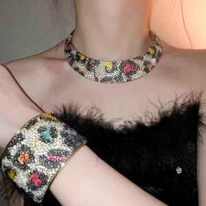 Close-up of leopard print metal necklace and bracelet set with rhinestones on model
