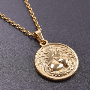 Macro shot of 18k gold-plated fox and moon embossed pendant on stainless steel chain