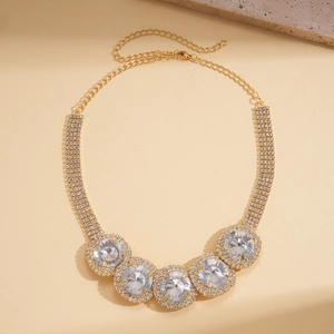 Macro shot of gold necklace with five large round crystals and pave-set diamond details